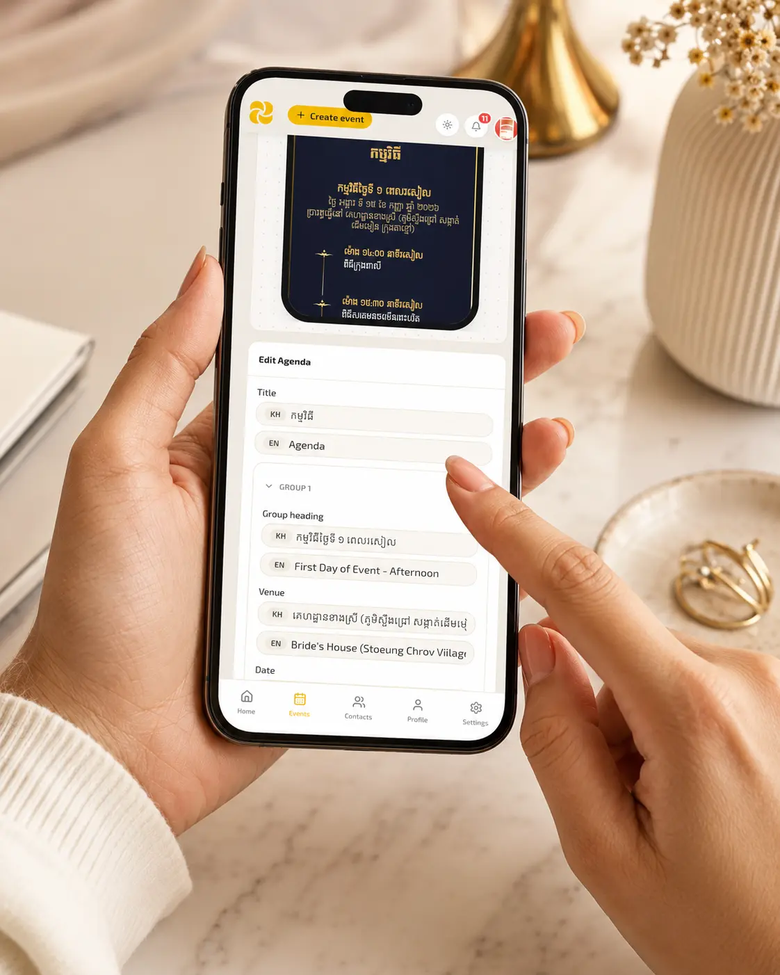 Person customizing a digital wedding invitation on their smartphone, with a beautiful preview visible on screen